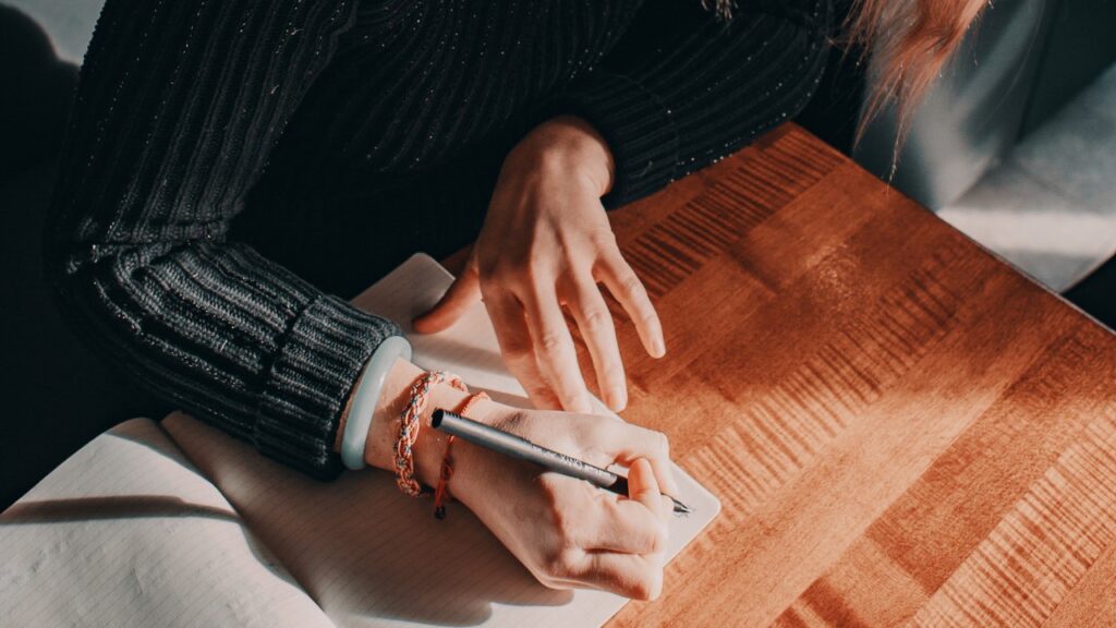 文字を書いている女性の手